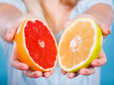 Erkek sarı ve kırmızı greyfurt narenciye meyve halfs closeup eller. Kadın diyetisyen sağlıklı beslenme beslenme tavsiye.
