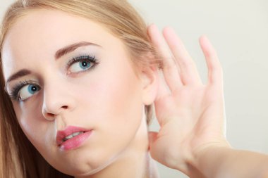 Closeup el gri üzerine dinleme kulağına. Dedikoducu kız kulak casusluk arkasında palm ile. Genç kadın dinleme gizli.