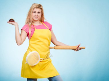 Lezzetli tatlılar tatlılar ev concept, pişirme. Önlük giyen kadın lezzetli çikolatalı kek, oklava ve kevgir, holding