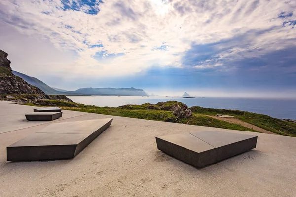 Kleivodden rest stop area viewpoint with stone seating bench. Arctic ocean view with clouds sky. Attractions along Andoya island Vesteralen Norway.