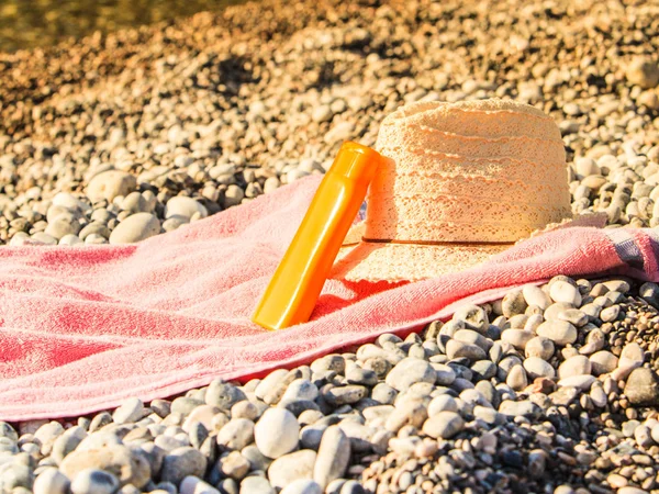 Strandaccessoires Een Handdoek Zonnebaden Zonnige Hoed Zonnebrandcrème Oranje Fles Stenen — Stockfoto