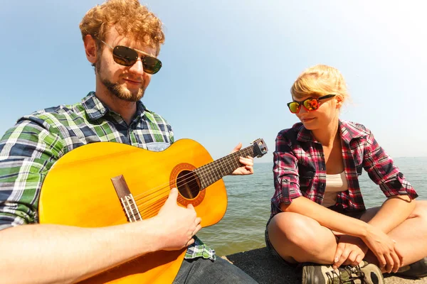 Jovem Hipster Tocando Guitarra Para Mulher Por Mar Oceano Bonito — Fotografia de Stock