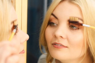Makyaj yapan, kirpiklerini fırçalayan, kirpiklerini fırçalayan kadınların yakın çekim görüntüleri..