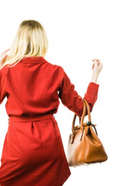 Zarif kırmızı kısa elbiseler giyen ve elinde şık kıyafetler sunan deri bir çanta tutan şık, güzel bir bayan..