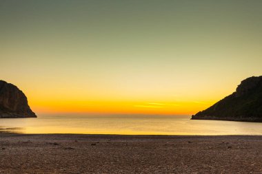 Yunanistan 'da deniz yüzeyinde gün doğumu veya gün batımı manzarası