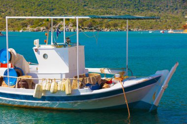 Turizm tatili ve seyahat. Yunan tatil beldesi marinasında mavi deniz yüzeyinde balıkçı teknesi.