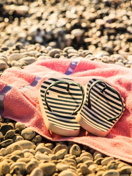 日光浴用毛巾上的海滩配件 鞋凉鞋翻盖 石岩沙子 — 图库照片