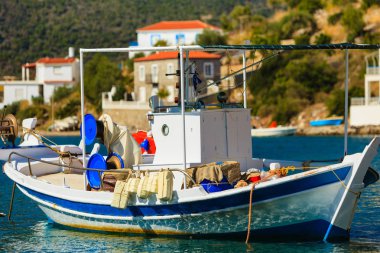 Turizm tatili ve seyahat. Yunan tatil beldesi marinasında mavi deniz yüzeyinde balıkçı teknesi.