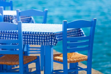 Deniz kenarındaki mavi masa ve sandalyeler deniz kıyısında Yunanistan 'da açık bir kafe restoranı açıyor. Yaz tatili.