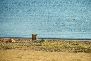 Bir tek şezlong boş kum plajındaki. Deniz gevşeme yerini.