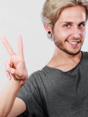 Başarı olumlu duygu kavramı. Zafer el işareti jest gösterilen genç üniversite öğrencisi