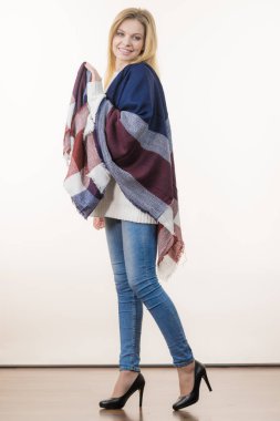 Kadın onun yumuşak renkli sıcak sonbahar şal şal rahat hissediyor. Mavi jeans, yüksek topuklu ayakkabılar kıyafet. Sonbahar kıyafeti aksesuarları kavramı.