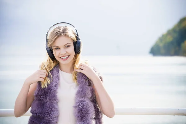 野外ながら音楽を聴いてくれる幸せな女性 歩くのが楽しいヘッドフォンを身に着けている10代の女性 — ストック写真