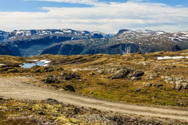 Norveç 'te Aurland ve Laerdal arasındaki dağ bölgesi. Uzakta kar zirveleri olan kayalık bir arazi. Ulusal turistik güzergah Aurlandsfellet.