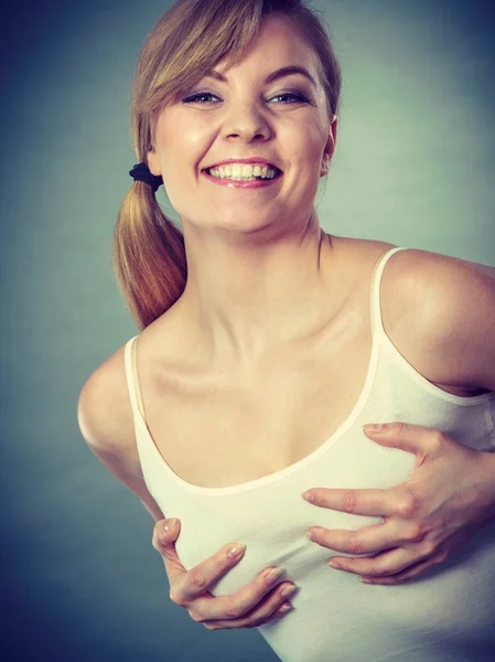 懐概念 乳房を押し上げる手の保有物の シャツを着ている若い幸せなうれしそうな女 — ストック写真