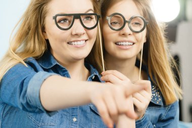 Dostluk, insan ilişkileri kavramı. İki mutlu kadın arkadaş ya da bir yere işaret kot gömlek giymiş kız.