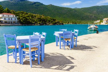 Deniz kenarındaki mavi masa ve sandalyeler deniz kıyısında Yunanistan 'da açık bir kafe restoranı açıyor. Yaz tatili.