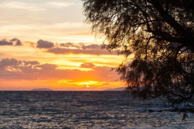 Yunanistan 'da deniz yüzeyinde gün doğumu veya gün batımı manzarası