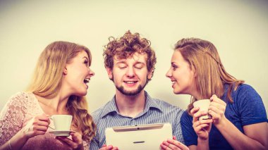 Tarama arkadaşlar dalga köpüğü enterne tablet üzerinde. Gençler evde kanepe rahatlatıcı oturan adam ve kadın kız adam.