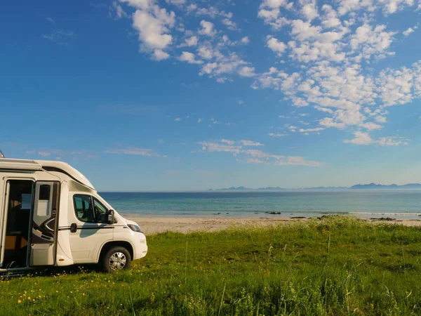 Camper van motor home on sea coast Gimsoysand beach in summer. Camping on ocean shore. Lofoten archipelago Norway. Vacation and travel in caravan.