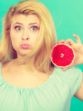 Kadın gülümseyen kız kırmızı greyfurt iki halfs narenciye meyve ellerinde yeşil holding. Sağlıklı bir diyet yemek. Yaz tatil kavramı eğlenceli.