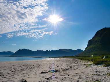 Manzaralı deniz kıyısı. Kuzey Bölgesi, Lofoten takımadaları Norveç 'te, ufukta dağları olan Gimsoya ve kumlu kumlu bir sahil. Turist eğlencesi.