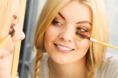 Makyaj yapan, kirpiklerini fırçalayan, kirpiklerini fırçalayan kadınların yakın çekim görüntüleri..