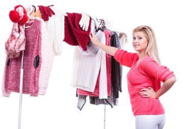 Genç kadın kararsızlık dolap ev dolap, teen sarışın kız giyim raf üzerinde onu sıcak moda kıyafet seçimi. Kış sonbahar kıyafetleri, konsept alışveriş toplama.