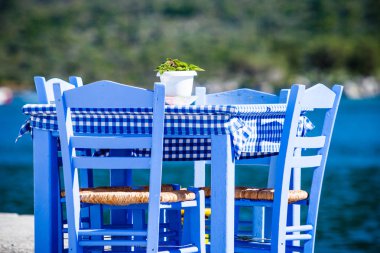 Deniz kenarındaki mavi masa ve sandalyeler deniz kıyısında Yunanistan 'da açık bir kafe restoranı açıyor. Yaz tatili.