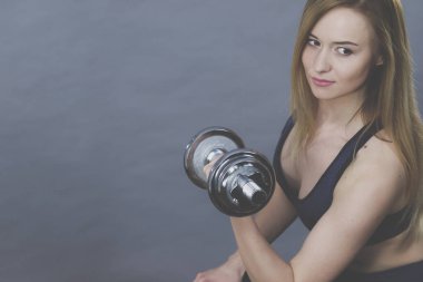 Güçlü kadın dumbell ağırlık kaldırma. Bina kas kazanma çekici sarışın model kız egzersiz uygun. Fitness ve vücut geliştirme, Grey