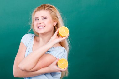 Sağlıklı beslenme, vitamin dolu ferahlatıcı yiyecekler. Lezzetli narenciye meyvesi tutan kadın, limon yarısı.