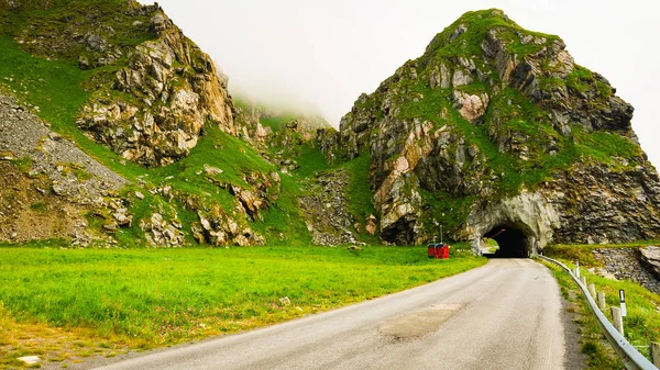 Road with old tunnel in green summer mountains, Norway. National tourist Andoya route.