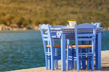 Deniz kenarındaki mavi masa ve sandalyeler deniz kıyısında Yunanistan 'da açık bir kafe restoranı açıyor. Yaz tatili.