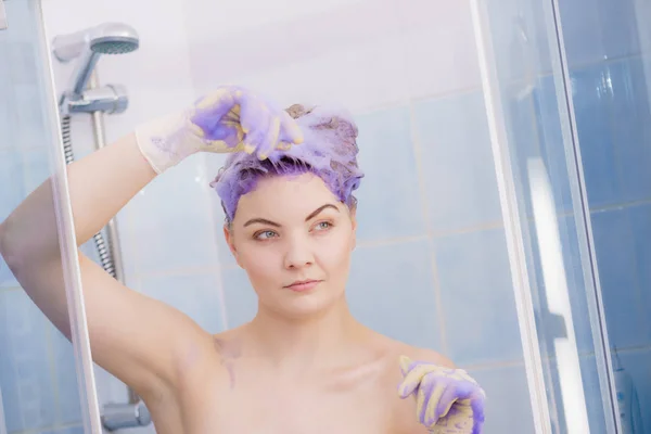 女人等着在头发上涂洗发水 有紫色洗涤产品的女性 家中金发碧眼 — 图库照片