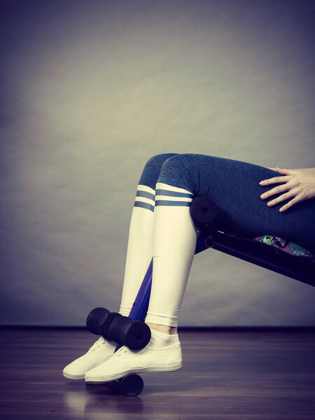 Unrecognizable woman wearing black leggings and long school looking socks training on bench for sit ups at home. Being fit and healthy, stomach muscles workout.