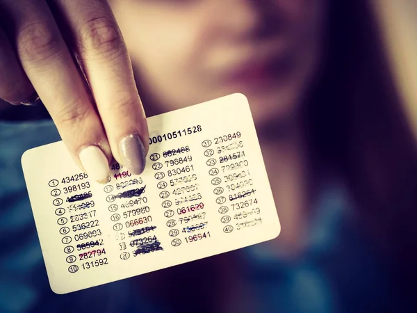 Woman holding card with codes for online transfers. Internet shopping, account protection, banking concept.