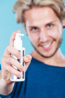 Saç modeli saç bakım ve geçici saç modeli kavramı. Yakışıklı genç bir adam, onun saç spreyi kozmetik uygulama moda sarışın metroseksüel modeli