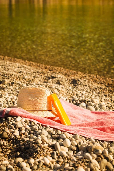 Strandaccessoires Een Handdoek Zonnebaden Zonnige Hoed Zonnebrandcrème Oranje Fles Stenen — Stockfoto