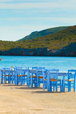 Deniz kenarındaki mavi masa ve sandalyeler deniz kıyısında Yunanistan 'da açık bir kafe restoranı açıyor. Yaz tatili.