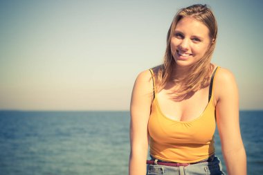 Tatil, yaz ve özgürlük kavramı. Güzel sarışın kız deniz kenarında açık rahatlatıcı