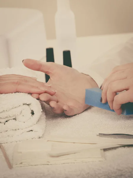 Woman hand on towel, beautician file nails. Beauty wellness spa treatment, manicure concept