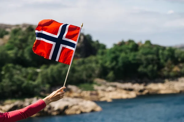 Tourist Hand Holding Norwegian Flag Rocky Stone Sea Coast Background — Stock Photo, Image