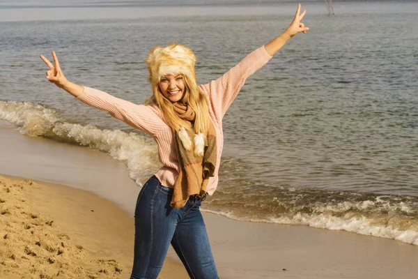 10代の女性は秋の天候の間にビーチで屋外で時間を過ごす セーター スカーフ 毛皮の帽子を身に着けて — ストック写真