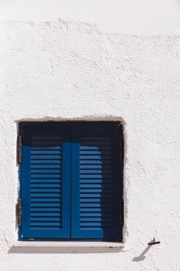 Tipik Yunan mimarisi konsepti ayrıntılarıyla anlatıyor. Yunanistan 'da evdeki mavi pencere panjurları.