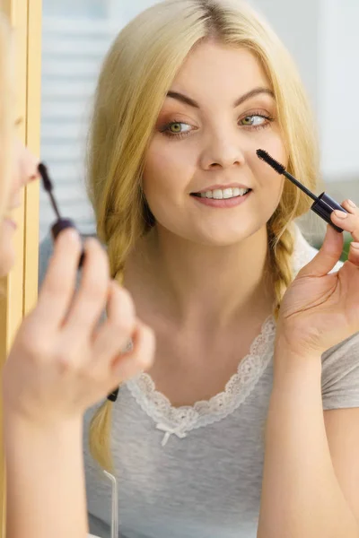 女人用黑色睫毛膏擦拭睫毛来化妆 女性美的容貌概念 — 图库照片