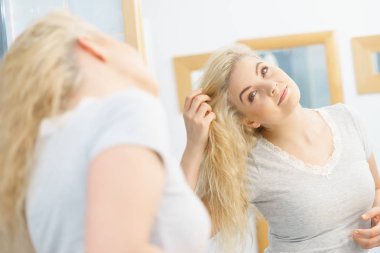 Islak sarı saçlı mutlu bir kadın. Duş aldıktan sonra temiz ve rahat hisseden pozitif bir kadın..