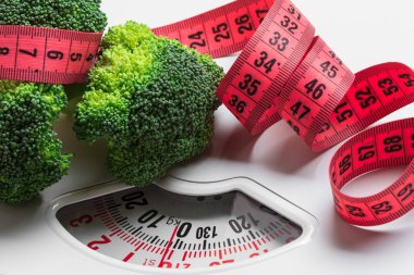 Sağlıklı beslenme zayıflama kilo kontrol konsepti. Yakından yeşil brokoli, beyaz pullarda şerit var.