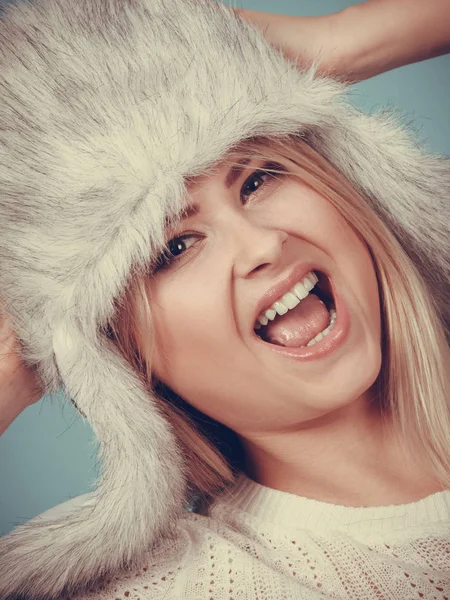 Accessories and clothes for cold days, fashion concept. Happy blonde woman in winter warm furry hat in russian style