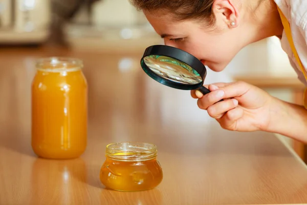 成熟的女人女性检查用放大镜检测蜂蜜食品 — 图库照片