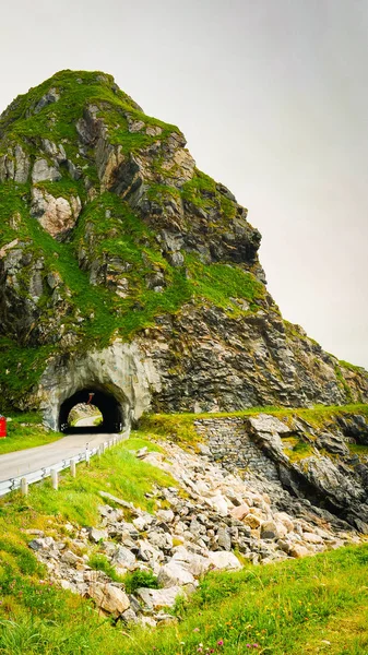 Road with old tunnel in green summer mountains, Norway. National tourist Andoya route.